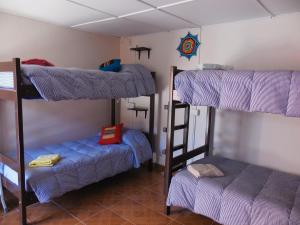 a room with three bunk beds in a room at Hostal Campo Base in San Pedro de Atacama