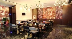 a restaurant with tables and chairs in a room at Zmax Changzhi Bayi Square in Changzhi