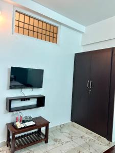 a living room with a coffee table and a flat screen tv at De villa Auro in Puducherry
