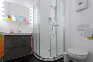 a white bathroom with a shower and a toilet at Premium Apartment beim Belvedere in Vienna