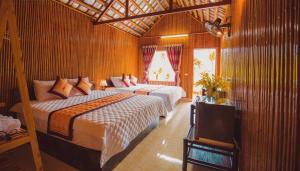 a bedroom with two beds and a television in it at Tràng An Valley Retreat in Nguyên Ngoại