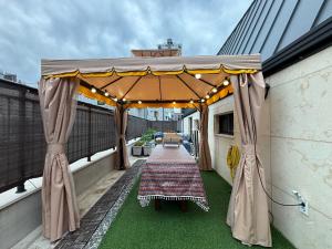 a covered patio with a table on a balcony at YYStay 감성 루프탑 in Seoul