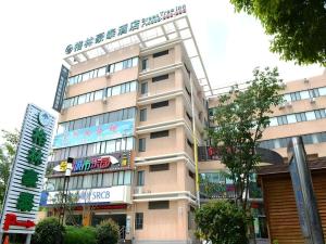 a tall tan building with a sign on it at GreenTree Inn Shanghai Waigaoqiao Free Trade Zone Express Hotel in Shanghai