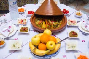 a table with a bowl of fruit and a bowl of food at Riad Dalia - Fes Medina in Fez