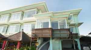 une maison avec un balcon à l'avant dans l'établissement The Studio Inn Nusa Dua, à Nusa Dua