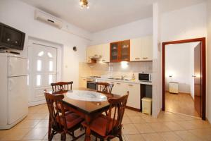 cocina con mesa de madera y sillas y cocina con mesa en Villa Rosanda Apartments en Trogir