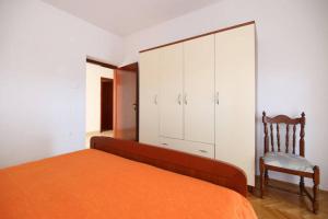 1 dormitorio con 1 cama, 1 silla y 1 armario en Villa Rosanda Apartments en Trogir