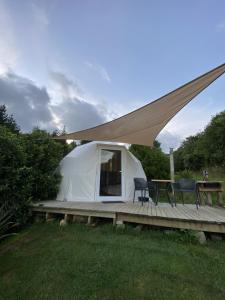 a tent with a table and chairs on a deck at The Geodesic Dome in Pohara Golden Bay in Pohara