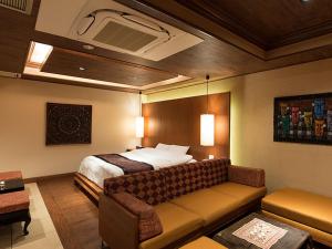 a hotel room with a bed and a couch at HOTEL PARIET Nakagawa - Adult Only in Fukuoka