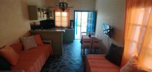 ein Wohnzimmer mit Sofa und eine Küche in der Unterkunft Elia - Studios Amorgos - near the sea in Aegiali
