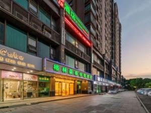 eine Stadtstraße mit vielen Gebäuden mit Neonschildern in der Unterkunft GreenTree Inn Jiaxing ZhongHuan South Road Zhonggang City Express Hotel in Jiaxing