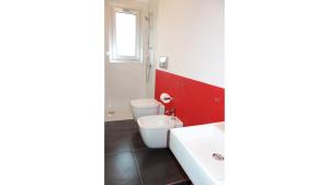 トラッペートにあるCasamattaの赤い壁のバスルーム(白いトイレ付)