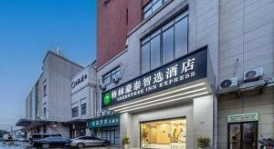 ein Gebäude mit einem Schild an der Seite in der Unterkunft GreenTree Inn Suzhou North Zhongshan Road Weiye Yingchun Plaza Business Hotel in Suzhou