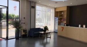 eine Bürolobby mit einem blauen Stuhl und einem Tisch in der Unterkunft 7 Days Premium Nanchang Xiaolan Industrial Park Bogang Metro Station in Lianxi