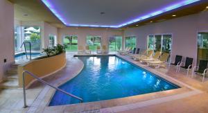 una piscina en una casa con sillas y una piscina en Altos de Belgrano Hotel Cabañas Golf y Spa en Villa General Belgrano