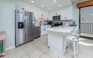 a kitchen with a stainless steel refrigerator and white cabinets at Phoenix VI 61115 in Orange Beach