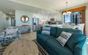 a living room with a blue couch and a table at Phoenix VI 61115 in Orange Beach