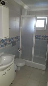 a bathroom with a shower and a toilet and a sink at Karya Apartments in Koycegiz +89 photos