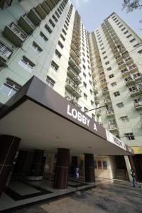 un bâtiment avec un panneau à l'avant d'un bâtiment dans l'établissement OYO Living 3091 Apt The Suites Metro By Ananda, à Bandung