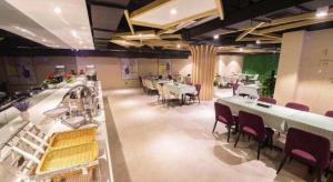 a restaurant with tables and chairs in a room at Lavande Hotel Jiande Xin'an River in Thousand Island Lake