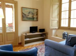 - un salon avec deux chaises et une télévision dans l'établissement Il Granaio di Palazzo Guicciardi, à San Bernardo