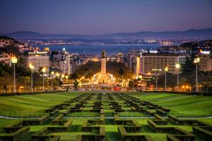 a park with a statue in the middle of a city at night at The Sky Lofts Lisbon - Guesthouse in Lisbon