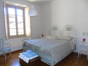 a bedroom with a bed and a chair and a window at Il Granaio di Palazzo Guicciardi in Ponte in Valtellina