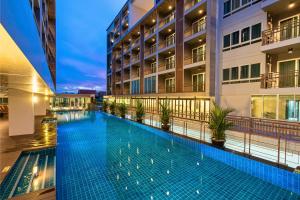 邦波Tisha Hotel ABAC Bangna的建筑物中间的游泳池