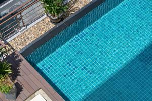 einen Blick über einen blauen Pool mit Pflanzen in der Unterkunft Tisha Hotel ABAC Bangna in Bang Bo