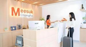 zwei Frauen stehen mit ihrem Gepäck vor einer Mesxiki-Apotheke in der Unterkunft Meesuk ChiangRai Hotel in Chiang Rai