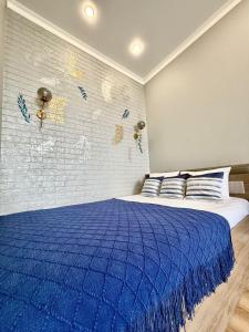 a bedroom with a blue blanket on a bed at Новые апартаменты рядом с EXPO in Taldykolʼ