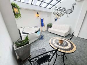 a living room with a tub and a table and a couch at The Nest Resort Patong in Patong Beach