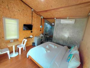 ein Schlafzimmer mit einem weißen Bett, einem Tisch und einem Stuhl in der Unterkunft Nathan Breeze Resort in Ko Muk