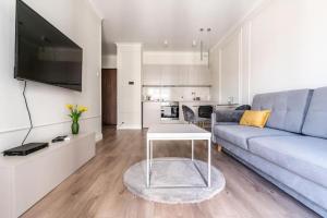 een woonkamer met een bank en een tafel bij Golden Prime Apartments - Mennica Residence - Luxury in City Center in Warschau +11 foto's