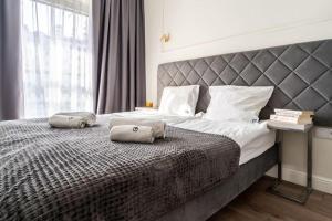 een slaapkamer met een groot bed met twee kussens erop bij Golden Prime Apartments - Mennica Residence - Luxury in City Center in Warschau