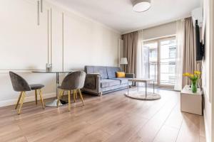 een woonkamer met een bank en een tafel bij Golden Prime Apartments - Mennica Residence - Luxury in City Center in Warschau