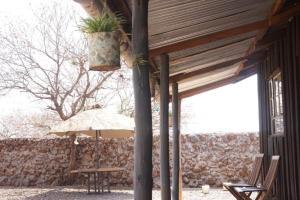 eine Terrasse mit einem Tisch und einer Topfpflanze auf einem Gebäude in der Unterkunft Oldonyo Musa Camp Amboseli in Rift Valley + 48 Fotos