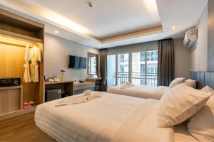 ein Hotelzimmer mit zwei Betten und Balkon in der Unterkunft Tisha Hotel ABAC Bangna in Bang Bo