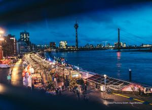 a view of a river and a city at night at Hotel Kö59 Düsseldorf - Member of Hommage Luxury Hotels Collection in Düsseldorf +55 photos