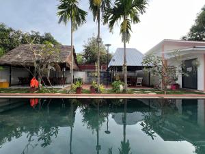 ein Haus mit einem Pool und Palmen in der Unterkunft Spacious Khmer Villa - Pool - Fast Wi-Fi in Phumĭ Réach Born