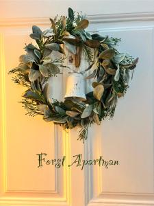 a wreath on a door with a bell on it at Forst Apartman in Eger