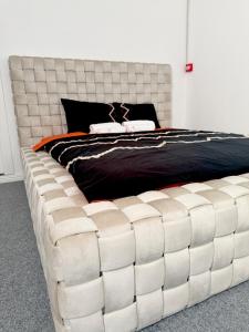 duże białe łóżko z dużym, pikowanym zagłówkiem w obiekcie Ap9 3 min from Christmas Market curte parcare w Krajowej