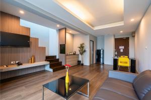 ein Wohnzimmer mit Sofa und Tisch in der Unterkunft Tisha Hotel ABAC Bangna in Bang Bo