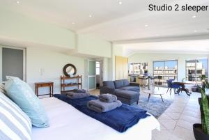 a bedroom with a bed and a living room at Atlantic Sky Penthouses 3-Bedroom and Studio with Breathtaking Views in Cape Town