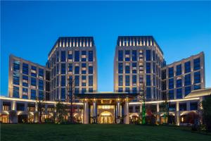 two tall buildings with a gazebo in front of it at New Century Grand Hotel Zunyi in Zunyi