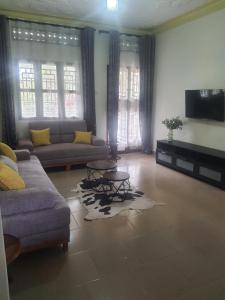 ein Wohnzimmer mit Sofa und Fernseher in der Unterkunft 41 Nile Bridge Villa in Jinja + 4 Fotos