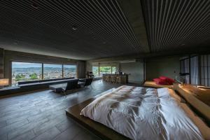 a bedroom with a large bed and a large window at Matsumoto Jujo in Matsumoto