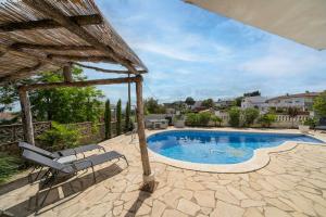 a swimming pool with two lounge chairs and an umbrella at Casa Felic 12 personen, familiehuis met hottub in Lloret de Mar