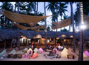 eine Gruppe von Menschen, die im Sand an einem Strand sitzen in der Unterkunft Song Anh Mui Ne Guesthouse in Mui Ne