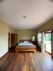 une chambre avec un lit et un parquet dans l'établissement d'Oasis Mountain Resort, à Puncak